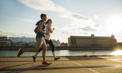 Young couple running by the riverside